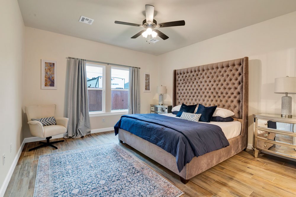 This image showcases a spacious and inviting master bedroom with a focus on elegance and comfort.