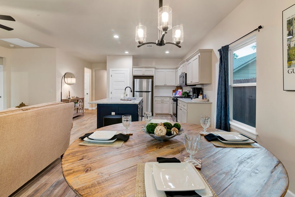 This image captures a beautifully staged open-concept dining and kitchen area, ideal for highlighting the functional and inviting flow of the home.