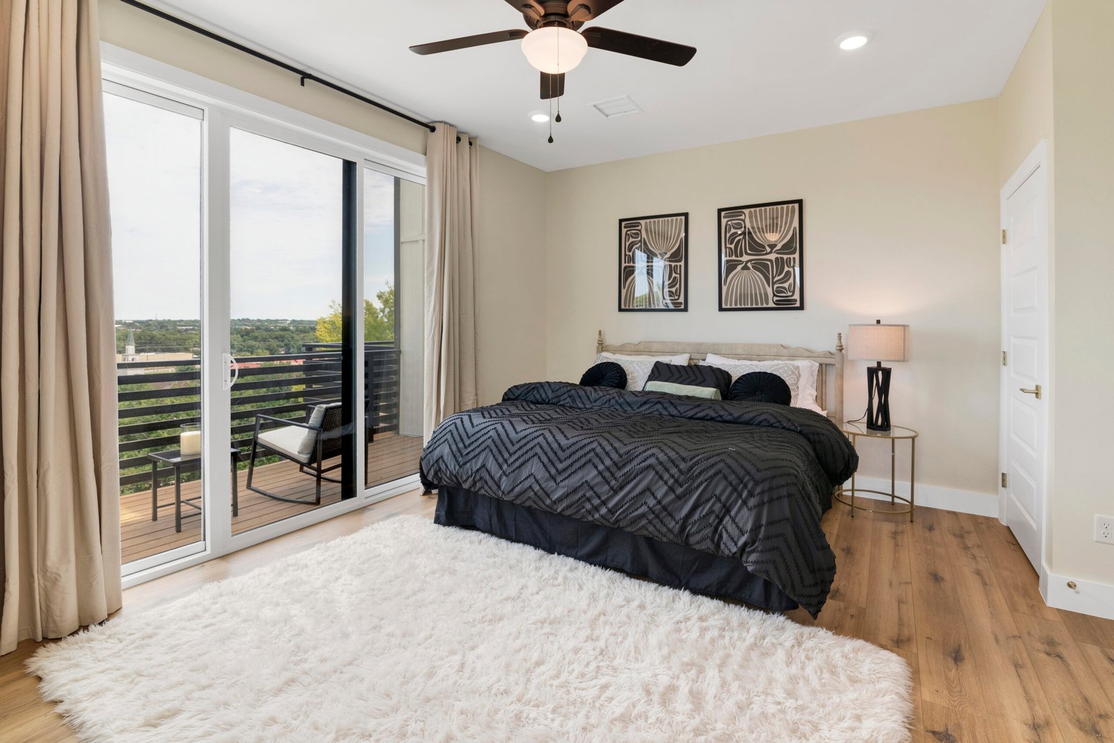 This image features a bright and airy master bedroom with a luxurious touch. The room is designed to maximize natural light,