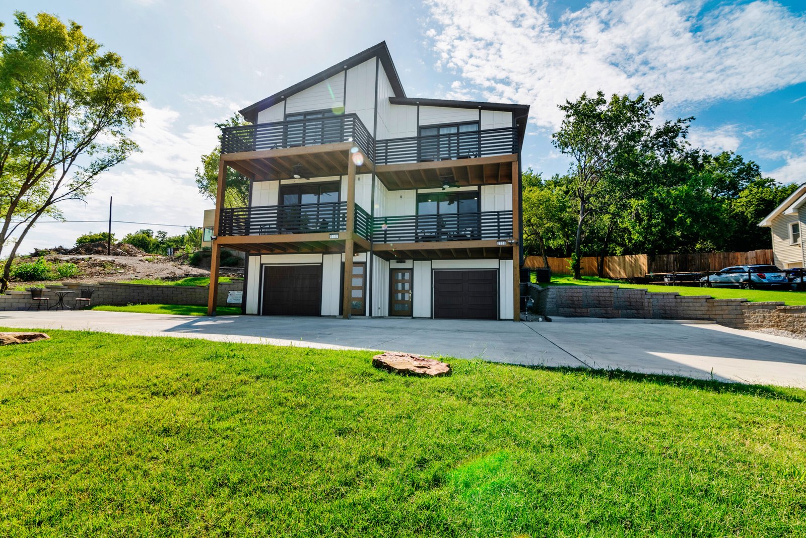 This image showcases a modern multi-level home with an eye-catching architectural design and abundant curb appeal.